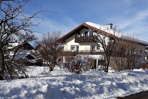 A two-story building with a balcony, surrounded by snow-covered ground and leafless trees. - Waltenberger Sonthofen (Sonthofen)