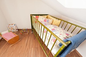 Una habitación infantil con una litera, una mesita con mantel a cuadros y un juguete.