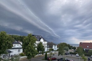 Ein Wohngebiet mit Häusern, ein weißes Gebäude mit 'Seeblick' auf der Fassade und eine Straße mit parkenden Autos.
