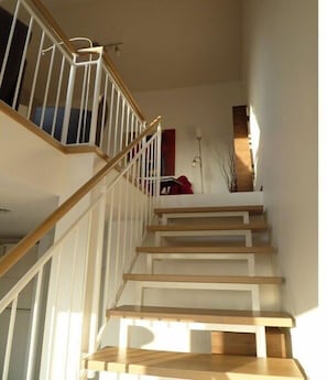 Eine Treppe mit Holzboden und weißen Geländern.