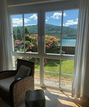 Ein Zimmer mit einer großen Schiebeglastür, die zu einem malerischen Ausblick ins Freie führt.