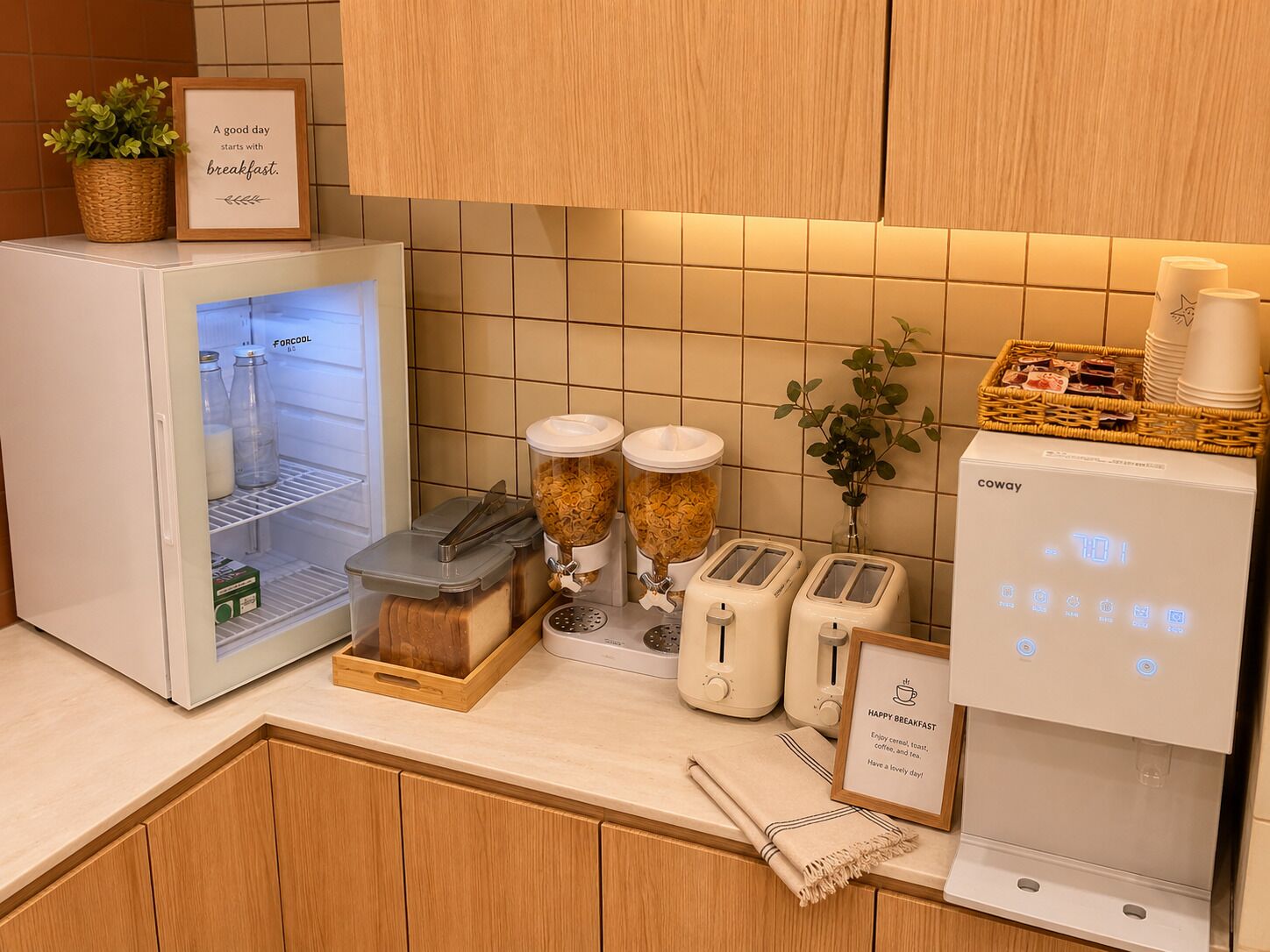 Eine Küche mit Kühlschrank, zwei Toastern, einer Kaffeemaschine und einem Schild mit der Aufschrift 'HAPPY BREAKFAST'.