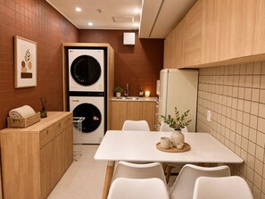 Cocina compacta con zona de comedor, lavadora y refrigerador.