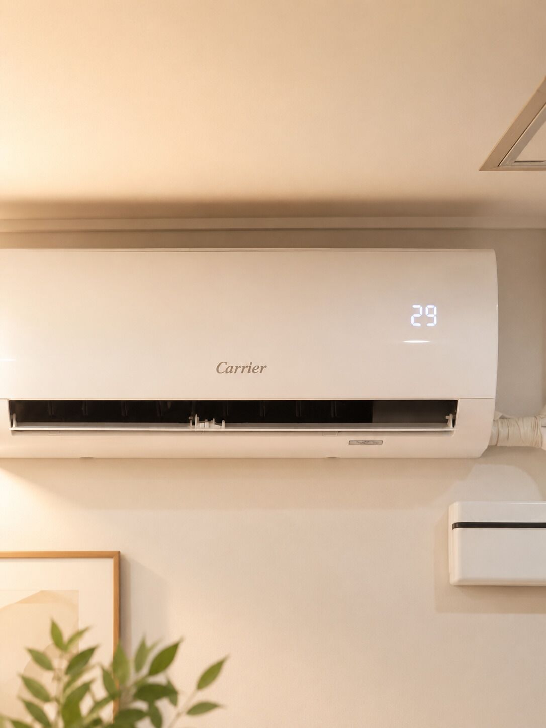 A Carrier air conditioning unit mounted on a wall with a digital display showing the temperature.
