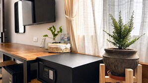 A compact kitchen with a microwave, a small refrigerator, a potted plant, and a wicker basket on the counter. - B&B Chill Home (Ho Chi Minh City)