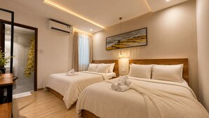 A hotel room with two beds, a wooden headboard, a painting, and a potted plant. - B&B Chill Home (Ho Chi Minh City)