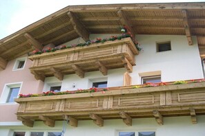 Un immeuble à plusieurs étages doté de balcons en bois ornés de fleurs.