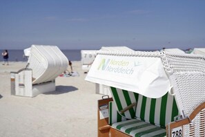 Beach chairs with white canopies and green stripes, labeled 'Norden Noorddeich.' - Holiday apartment with 1 bedroom (Norden)