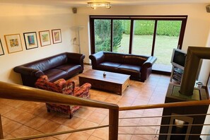 Ein Wohnzimmer mit zwei Sofas, einem Couchtisch und einem Fernseher.