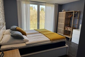 Ein Schlafzimmer mit Bett, Kleiderschrank und einem fensterbepflanzten Fenster.