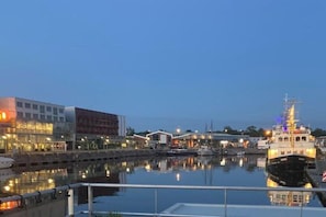 A waterfront marina with boats, buildings, and a dock.