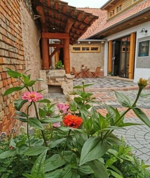 Ein Innenhof mit Backsteinmauer, einer Holzpergola und einem Steinweg.