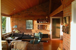 Ein gemütliches Wohnzimmer mit Kamin, Fernseher und einer bequemen Sitzecke.