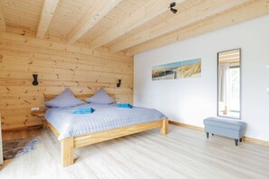 A wooden-paneled room with a bed, a bench, and a window. - Holiday home with 4 bedrooms (Nettersheim)