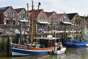 Ein Hafen mit Booten, ein Gebäude mit der Aufschrift 'HAUS HATEN' und ein weiteres mit 'POLARIS' auf einem Boot.