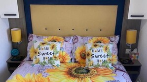 A bed with a floral bedspread and two pillows with 'Home Sweet Home' text. - Sunflower Lodge Luxury Pet Free Holiday Caravan (Filey)