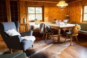 A cozy room with a wooden interior, a dining table set with glasses, and a bench. - Zirbenchalet Eggriedl (Großarl)