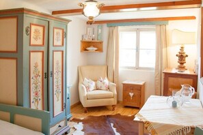A room with a wooden cabinet, a chair, a small table, a window, and a lamp. - Holiday home in Uttendorf with Wi-Fi (Uttendorf)