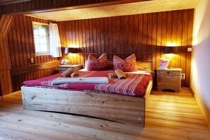 A wooden-paneled room with a bed, two bedside tables, and a window. - Holiday home in Sebnitz with swimming pool (Sebnitz)