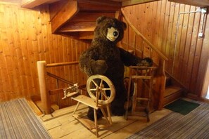A wooden interior with a large teddy bear, a spinning wheel, and a ladder. - Holiday home in Mittelberg with Wi-Fi (Mittelberg)