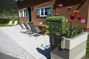 A building with a mailbox, outdoor seating, and a view of the surrounding landscape. - Holiday home in Mittelberg with Wi-Fi (Mittelberg)