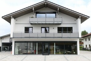 A two-story building with a balcony, large windows, and a covered entrance. - Holiday apartment with 2 bedrooms (Chieming)