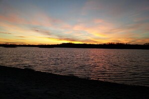 A sunset over a calm body of water with a silhouette of trees in the background. - Holiday rooms in Schlepzig with barbecue (Schlepzig)