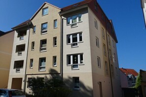 A multi-story building with balconies, windows, and a red roof. - Holiday apartment in Waren with Wi-Fi (Waren)