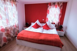 Ein Schlafzimmer mit Bett, Nachttischen und einem Spiegel.