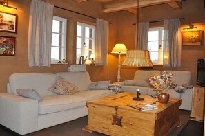 Ein gemütliches Wohnzimmer mit Couchtisch aus Holz, zwei Sofas, einer Lampe und einer Blumenvase.