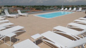 A rooftop pool with white lounge chairs and a clear view of the surrounding buildings. - Contemporary hideaway with pool (Bibione)