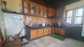 Una cocina con armarios de madera, encimera negra y salpicadero de azulejos.