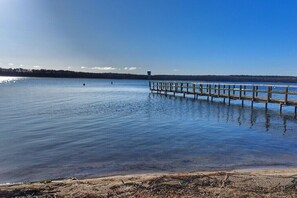 A calm lake with a wooden dock extending into the water. - Beach house by the lake - with boat & canoe (Hohen Viecheln)