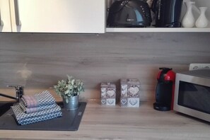 Eine Küche mit Mikrowelle, Kaffeemaschine und Aufbewahrungsboxen mit Herzmuster.