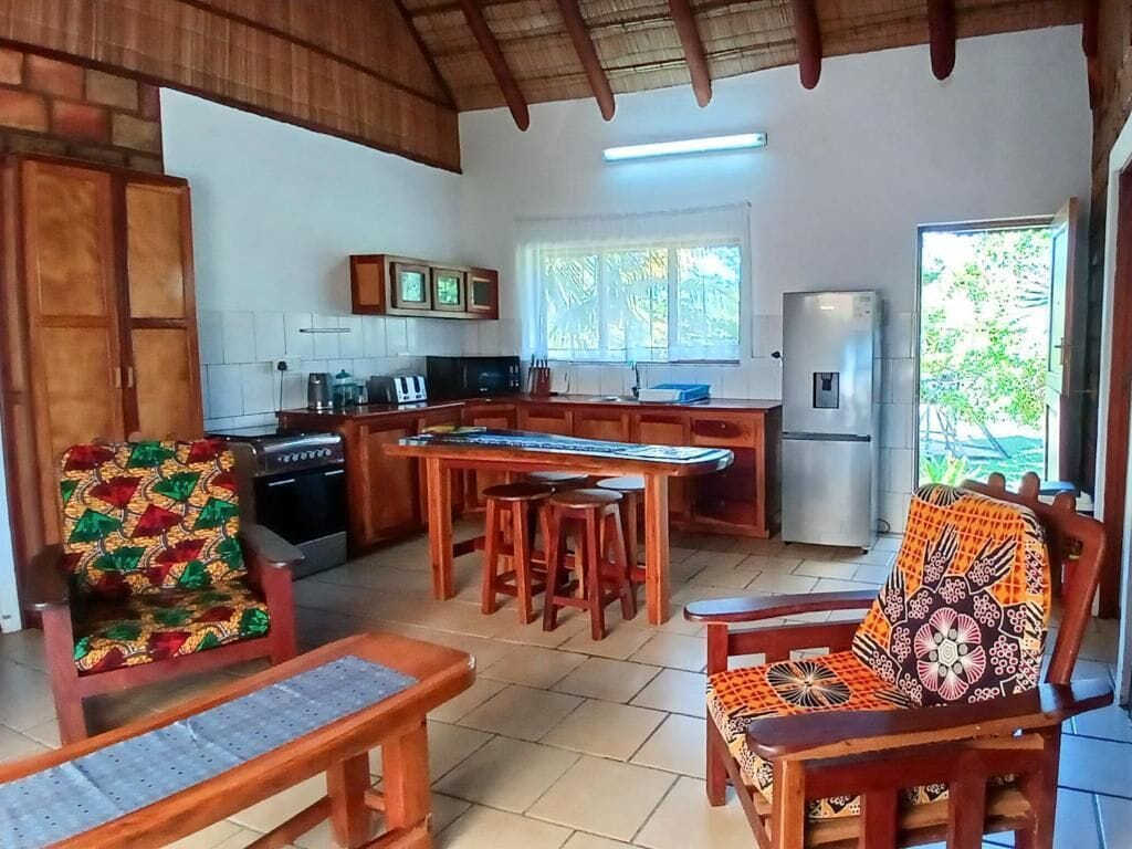 Una cocina con isla central, muebles de madera y un refrigerador.