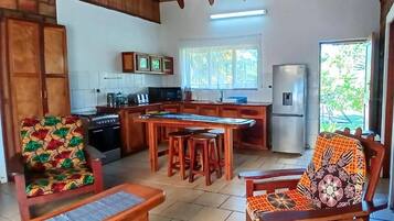 Una cocina con isla central, muebles de madera y un refrigerador.