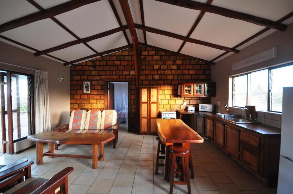 Una cocina rústica con pared de ladrillo, muebles de madera y un amplio ventanal.