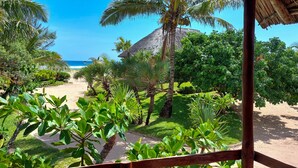 Un complexe hôtelier tropical doté d’une structure à toit de chaume, d’une végétation luxuriante et offrant une vue dégagée sur l’océan.