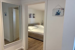 Ein Schlafzimmer mit Bett, Spiegel und Wanddeko.