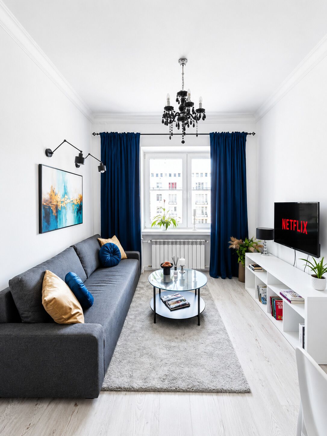 A modern living room with a grey sofa, a coffee table, a TV, and a bookshelf.
