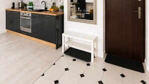 A modern kitchen with black cabinets, a wooden countertop, and a tiled backsplash. - Lumina Cozy Apartment in Warsaw Centre (Warsaw)