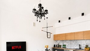 A modern living room with a TV, sofa, coffee table, and dining area. - Lumina Cozy Apartment in Warsaw Centre (Warsaw)
