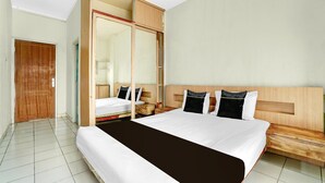 Une chambre d’hôtel avec un grand lit, une armoire en bois et un banc en bois.