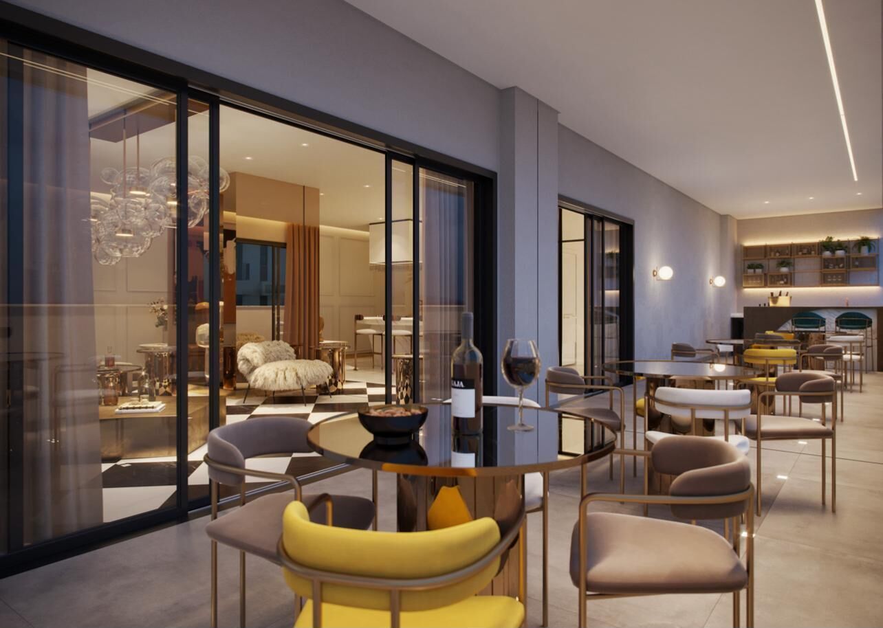 A modern interior with a dining area, kitchen, and a view through large glass doors.