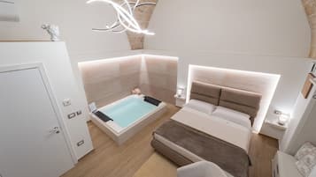 Un dormitorio moderno con una cama grande, una bañera separada y una zona de estar.