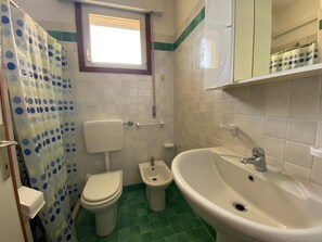 Ein Badezimmer mit Toilette, Bidet und Waschbecken.