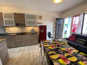 Eine moderne Küche mit Holzausstattung, einem Kühlschrank und einem Essbereich mit bunten Tischdecken.