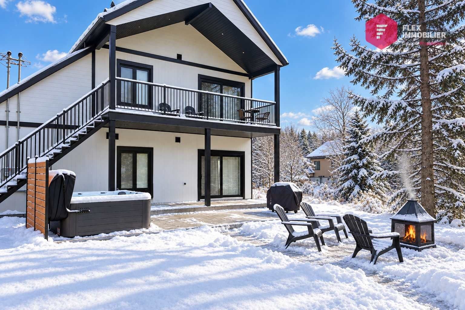 Une maison à deux étages dotée d’un balcon, d’un jacuzzi et d’un espace salon extérieur.