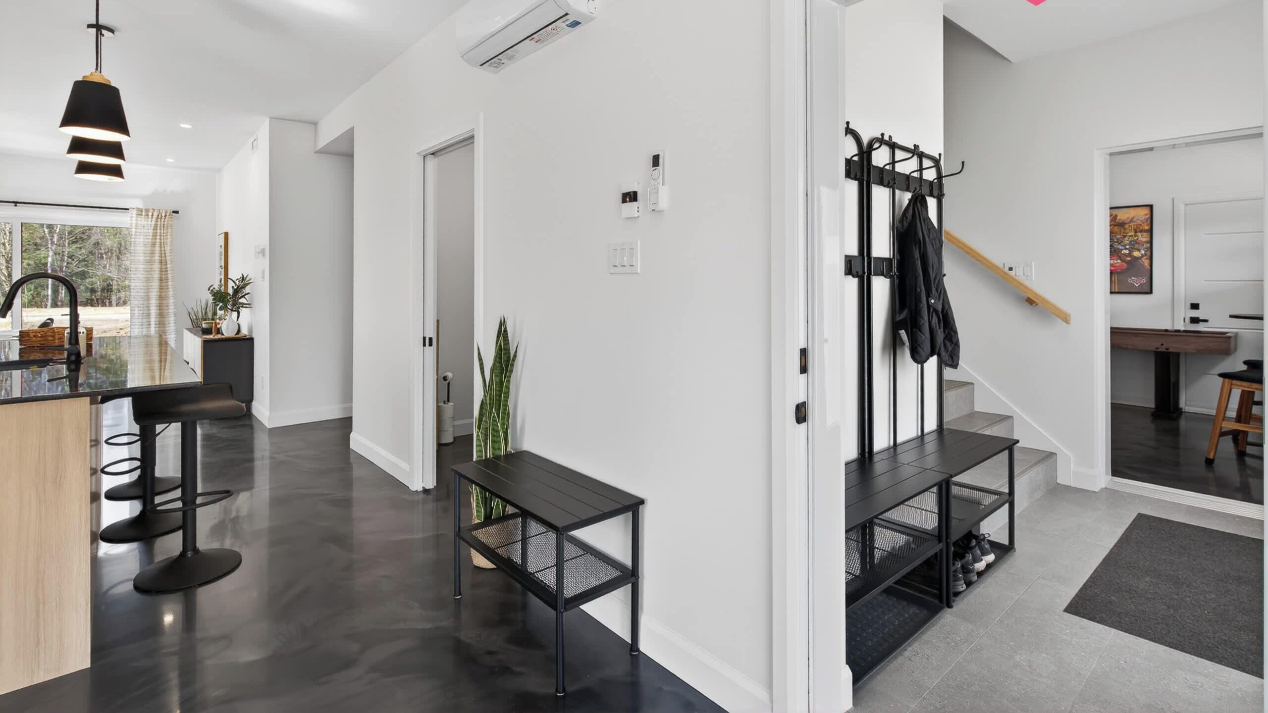 Un interno moderno con cucina, zona pranzo e una scala.