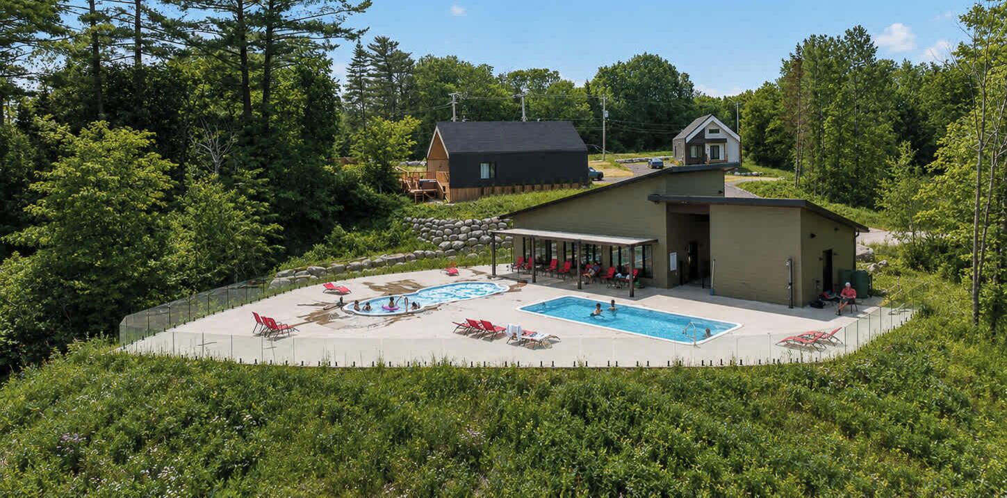 Un resort con piscina, lettini e una zona coperta.